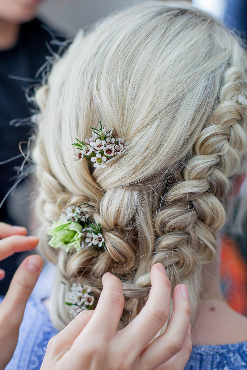 Brautfrisur geflochten mit frischen Blumen für lange Haare